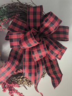 a red and black plaid bow on top of a wreath