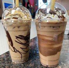 two iced coffees sitting on top of a counter