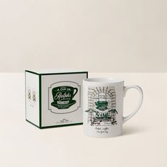 a white coffee mug sitting next to a box