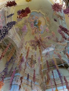 the ceiling is covered with many different colored flowers hanging from it's ceiling,