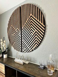 a wooden wall hanging on the side of a table next to a vase with flowers