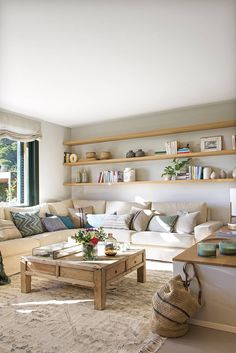 a living room filled with furniture and lots of shelves on the wall above it's coffee table