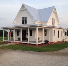 a large white house sitting on top of a lush green field