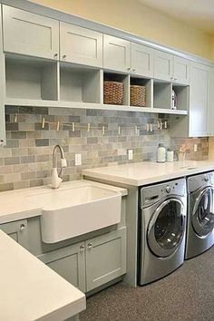 a washer and dryer in a small room with tile backsplashes