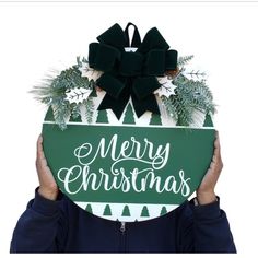 a person holding up a merry christmas sign