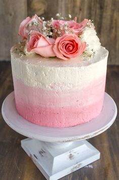 a pink and white cake with flowers on top