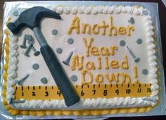 a sheet cake with a hammer and ruler on it that says another year nailed down