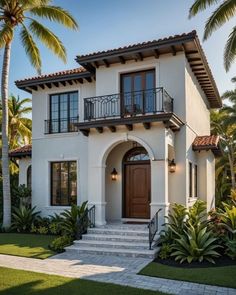 a white house with palm trees in the front yard and stairs leading up to it