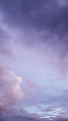 an airplane is flying high in the sky with clouds above it and another plane on the ground below