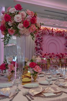 the table is set with pink and white flowers