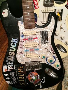 an electric guitar with stickers all over it