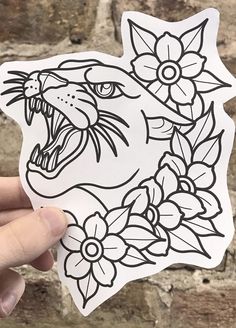 a hand holding up a sticker with an image of a tiger and flowers on it