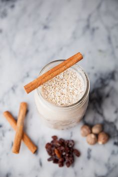 a glass jar filled with oatmeal, cinnamon sticks and raisins