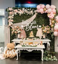 a baby shower is set up with balloons, flowers and teddy bears on the table