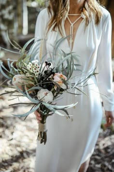 a woman in a white dress holding a bouquet of flowers