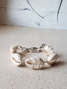 Summer ready bracelet with the prettiest cowries. Alternating wire wrapped cowries using your choice of gold plated or silver plated wire. Bold toggle clasp, and thick jumprings make this bracelet stand out. The additional jumprings also act as and an extender so it fits from 6.5" to 8.5" wrist.  Comes boxed and ready for gifting. Adjustable Chain Bracelet For Beach, Beach Jewelry With Adjustable Chain Bracelet, Adjustable Chain Beaded Bracelets For Beach, White Cowrie Shell Bracelet, Elegant Handmade Bracelets For Vacation, Adjustable Cowrie Shell Bracelet Jewelry, Adjustable Cowrie Shell Bracelet, White Oyster Bracelet Jewelry For Vacation, Elegant Adjustable Shell Bracelet