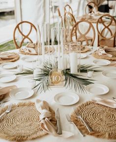 the table is set with plates and place settings