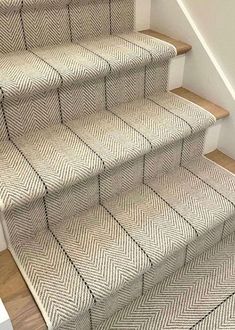 a cat is sitting on the carpeted stairs