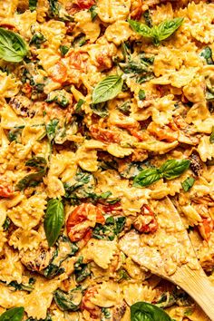 a pan filled with pasta and spinach on top of a table