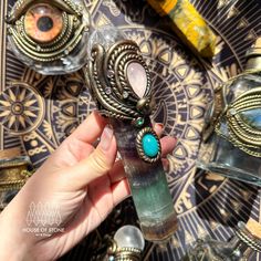 a person is holding an item in their hand near other items on a table with gold and blue accents