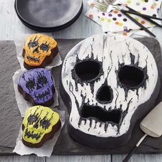 three decorated cookies sitting next to each other on top of a table with forks and spoons