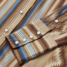 This stylish long-sleeve western shirt is crafted from 100% herringbone rayon, which has a smooth, silky feel and features our exclusive Sand Serape print. It has a single-point deep curved yoke, a single point patch pocket, a classic snap front and deep, four-snap cuffs. Cut with an easy, flattering drape, the blouse allows for all-day comfort and freedom of movement. Single Point Deep Curved Yoke Single Point Left Chest Patch Pocket Classic Snap Front Deep 4 Snap Cuffs 100% Rayon Imported Fitted Western Shirt With Button Closure, Western Style Snap Button Shirt, Western Button-up Tops With Pockets, Western-themed Cotton Shirt With Button Closure, Modern Cowgirl, Western Snap Button-up Shirt, Toddler Boots, Denim Boots, Long Sleeve Kids