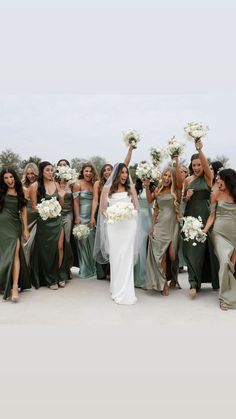 the bride and her bridal party are all dressed in green dresses with white bouquets