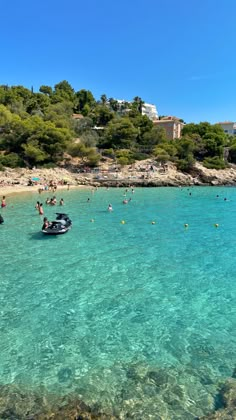 people are swimming in the clear blue water