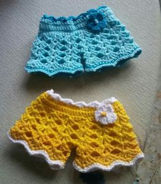 two crocheted shorts are laying on the floor next to each other and one has a flower in it