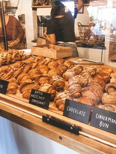 an assortment of croissants on display at a bakery