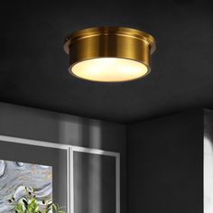 a light that is on above a window in a room with black walls and white trim