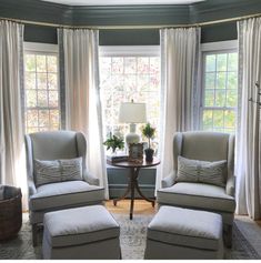 two white chairs sitting in front of a window