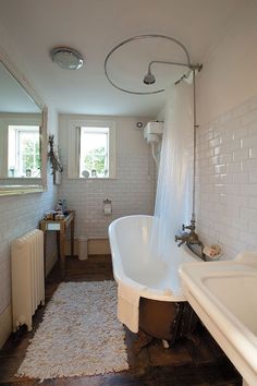 an old fashioned bathtub and sink in a bathroom with white tiles on the walls