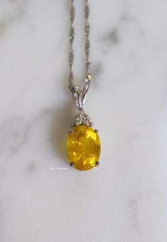 Metal: 14kt White Gold Stone: Yellow Sapphire And Diamond Stone Shapes: Round And Oval-Shape Yellow Sapphire Weight: 3.27 ctw, 9.84 x 7.82 mm Diamond Weight: .08 ctw, round diamonds Measurements Of Pendant From Bail To Bottom Of Pendant: 19.93 mm Weight of entire piece with chain: 2.50 grams Type of Chain: 1.2mm Diamond-cut Singapore Chain Length of Chain: 16 Inches Type of Lock: Spring Ring Note: Other chain styles and lengths available. Pendant can also be sold without chain. Please inquire if White Gold Oval Gemstones Fine Jewelry, Oval Yellow Gold Gemstones Fine Jewelry, Yellow Gold Oval Gemstones Fine Jewelry, Oval Yellow Gold Gemstones With Accent Stones, Oval Yellow Gold Gemstones For Anniversary, Yellow Gold Oval Gemstone For Anniversary, Luxury Oval Yellow Gold Gemstones For Anniversary, Fine Yellow Oval Jewelry, Elegant Yellow Oval Gemstones