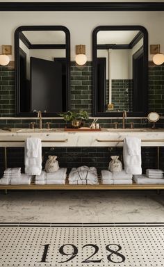 a bathroom with two sinks, mirrors and towels