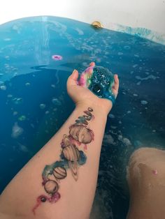 a person's arm with tattoos on it in the water