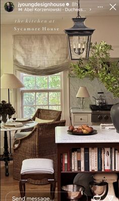 an image of a kitchen with bookshelves and lamps on the table in front of it