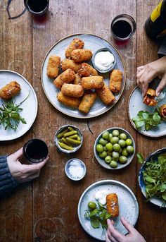 people are sitting at a table with plates of food