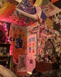 the room is decorated with many colorful pictures and posters hanging from the ceiling above it