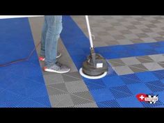 a person using a mop to clean the floor with a blue and black checkered pattern