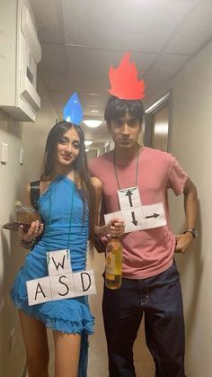 two people dressed up in costumes standing next to each other and holding signs with words on them