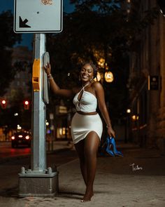 a woman standing next to a street sign