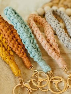 four different colored crocheted key chains on a table