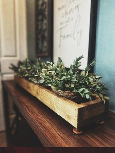 there is a plant in a wooden box on the table