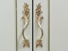 an ornate door handle on a white cabinet