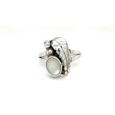 This unique sterling silver ring features a dainty oval mother-of-pearl cabochon, two beaded drops of silver, and a large feather-like leaf. All together these elements create and interesting asymmetrical design reminiscent of its southwestern and Navajo influences. This ring is sure to add interest to any jewelry collection! Details: Material: Sterling Silver Gem(s): Mother of Pearl: Gem Color: Milky White Ring Size: 7 Total Weight: 3.1 FREE domestic shipping by USPS Priority Mail delivery confirmation and includes insurance. If the item is to be shipped internationally, Etsy will calculate postage. Please notify us at purchase if you are buying more than one item, and we will gladly combine shipping. 7-day "no hassle" return policy money-back guarantee. If for any reason you are not 100% Silver Mother Of Pearl Anniversary Ring, Elegant Oval Nickel-free Moonstone Ring, Elegant Oval Moonstone Nickel-free Ring, Silver Oval Rings With Mother Of Pearl, Silver Oval Mother Of Pearl Rings, Silver Mother Of Pearl Ring As Gift, Silver Pearl Ring With Mother Of Pearl As Gift, Silver Mother Of Pearl Ring For Gift, Anniversary Silver Mother Of Pearl Rings