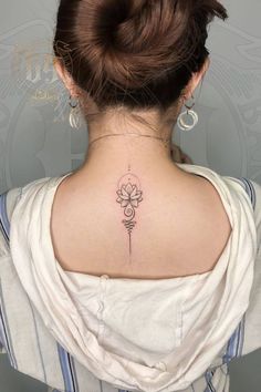 a woman with a flower tattoo on her back neck and behind the neck is a white shirt