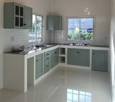 an empty kitchen with green cabinets and white flooring is pictured in this image from the inside