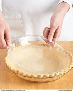 a person in an apron is making pie crusts on top of a wooden table