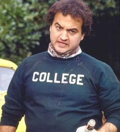 a man in a college sweater holding a bottle